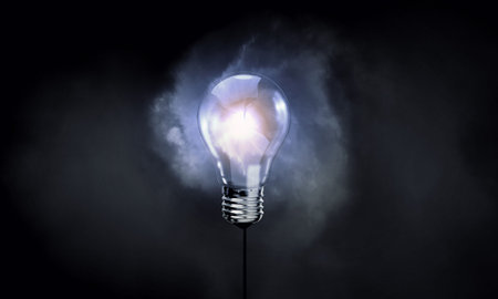 Glowing inverted light bulb on dark background