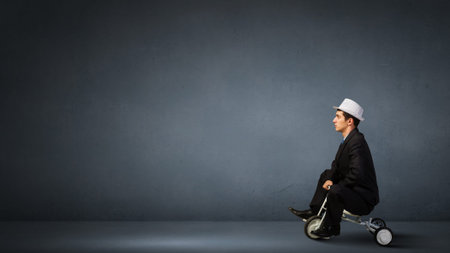 Young funny businessman riding three wheeled bicycleの写真素材