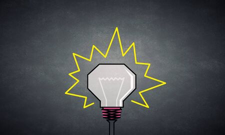 Glowing inverted light bulb on dark backgroundの写真素材