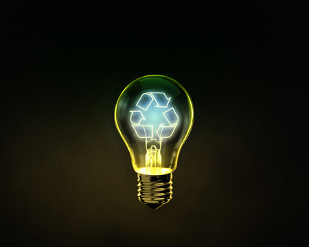 Glowing lightbulb with recycle symbol inside on dark backgroundの写真素材