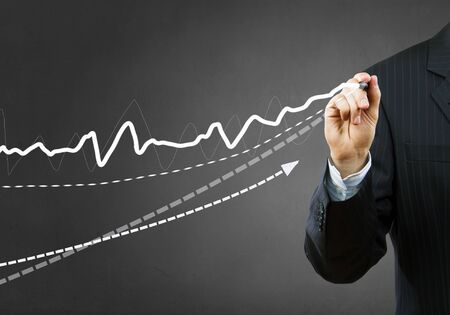 Businessman hand drawing business graphs on media screenの写真素材