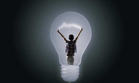 Back view of girl inside of light bulbの写真素材