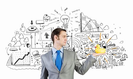 Funny businessman with yellow rubber duck toyの写真素材