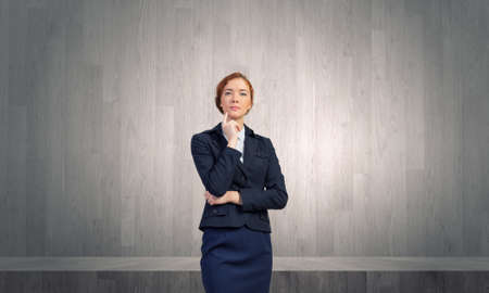 Young thoughtful businesswoman with finger on chinの写真素材