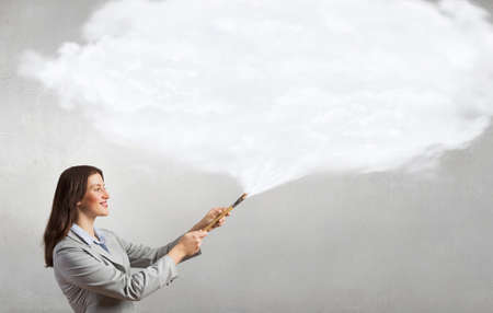Young pretty businesswoman holding paint brush. Creativity conceptの写真素材