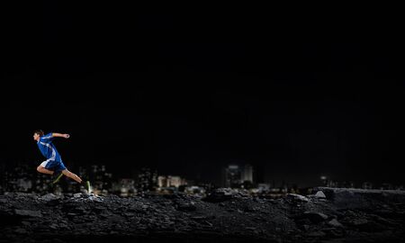 Running man in blue sport wear on black backgroundの写真素材