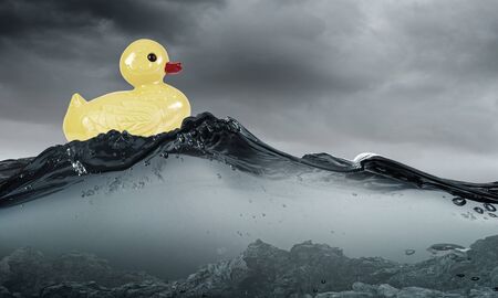 Yellow rubber duck toy floating in waterの写真素材