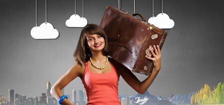 Young retro woman with her vintage baggage on shoulderの写真素材