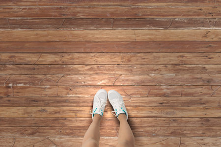 Top view of female feet wearing white sneakers