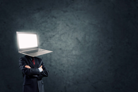 Businessman with laptop instead of his headの写真素材