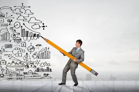 Businessman drawing plan strategy success with huge pencilの写真素材