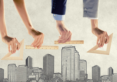Close up of male hand measuring with ruler model of city