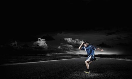Running man in blue sport wear on black backgroundの写真素材