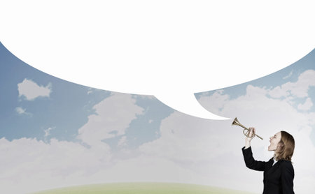 Young businesswoman in suit proclaiming something in hornの写真素材