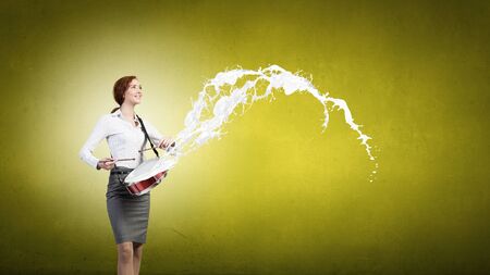Young businesswoman on color background playing drumの写真素材