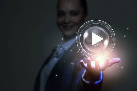 Businesswoman with media player button in palmの写真素材