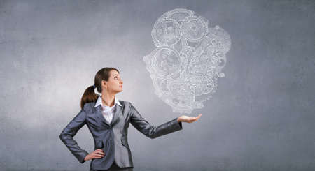 Attractive businesswoman holding in palm working gears mechanismの写真素材