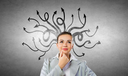 Young pensive businesswoman and thoughts coming out of her headの写真素材