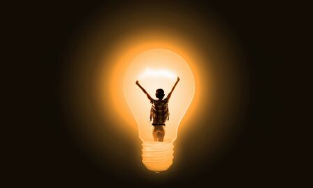 Back view of girl inside of light bulbの写真素材