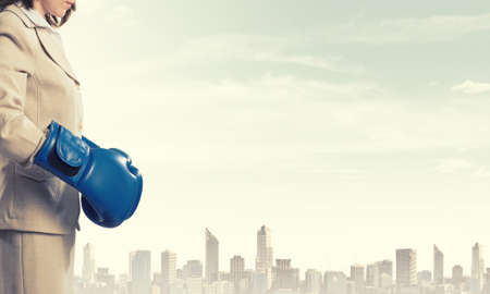 Young confident businesswoman wearing blue boxing glovesの写真素材