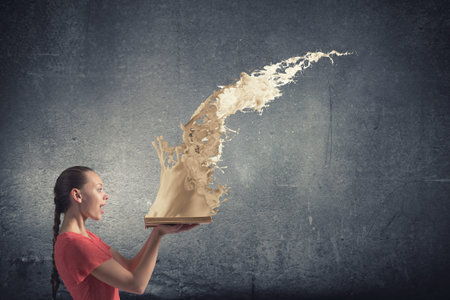 Young emotional woman in red dress with book in hands