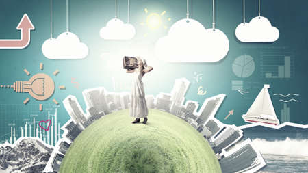 Woman with suitcase in white long dress and hatの写真素材