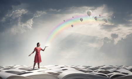 Young woman in red dress with book in handの写真素材