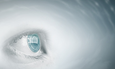 Female blue eye on cloudy sky backgroundの写真素材