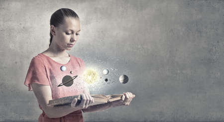 Young woman with book exploring planets of sun systemの写真素材