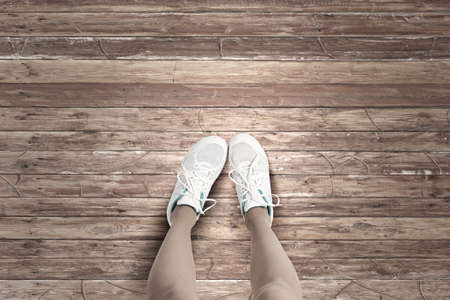 Top view of female feet wearing white sneakersの写真素材