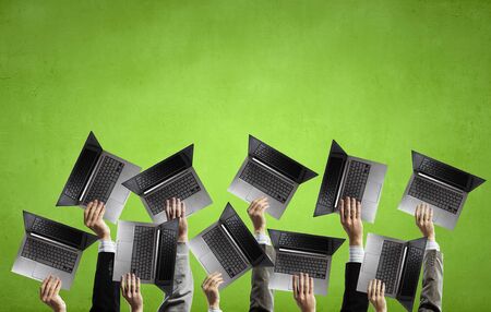 Many business people holding in hands laptopsの写真素材