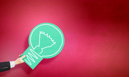 Close up of hand holding glowing light bulbの写真素材