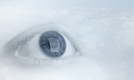 Female blue eye on cloudy sky backgroundの写真素材