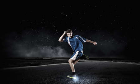 Running man in blue sport wear on black backgroundの写真素材