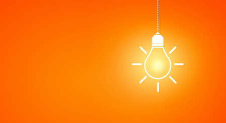 Glowing light bulb on dark background hanging from aboveの写真素材