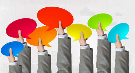 Group of business people holding chat cards in raised handsの写真素材