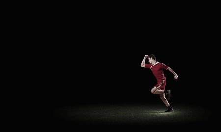 Running man in red sport wear on dark backgroundの写真素材