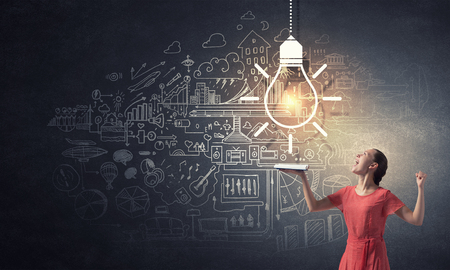 Young emotional woman in red dress with book in handの写真素材
