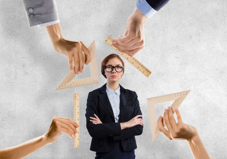 People hands measuring businesswoman with wooden rulersの写真素材
