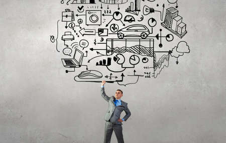 Young businessman lifting his great business plan above headの写真素材