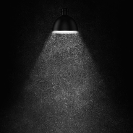 Cement wall and glowing lamp hanging from aboveの写真素材