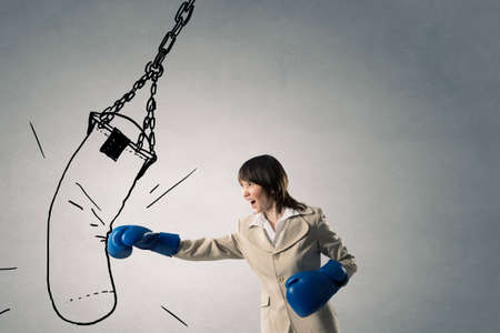 Young businesswoman in blue boxing gloves competition readyの写真素材
