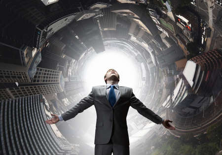 Confident businessman with hands spread apart on cityscape backgroundの写真素材