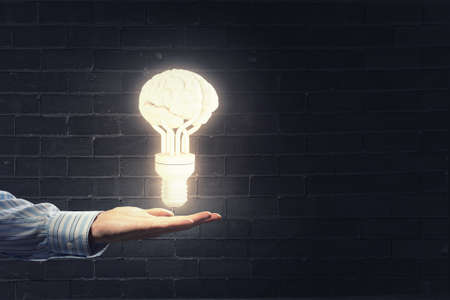 Close up of hand holding light bulb in palmの写真素材