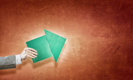 Hand holding rising arrow representing business growthの写真素材