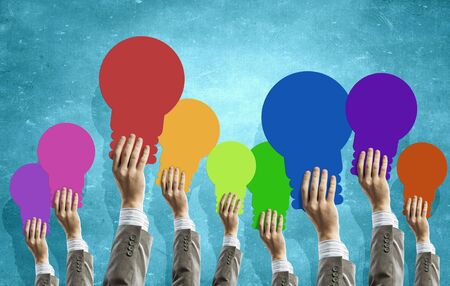 Many human hands holding light bulb signsの写真素材