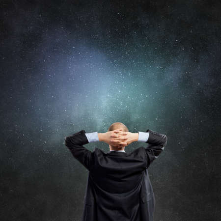 Back view of businessman looking at big light bulbの写真素材