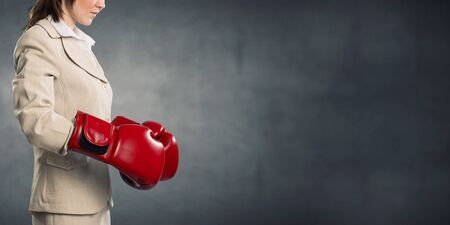 Young businesswoman in red boxing gloves competition readyの写真素材