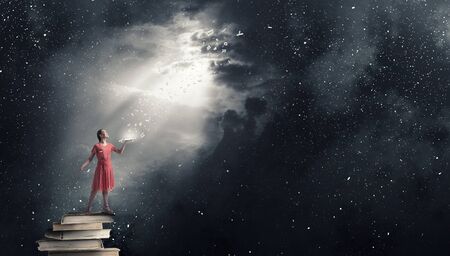 Young woman in red dress with book in handの写真素材