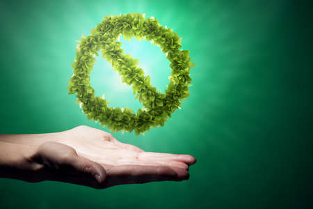 Close up of human hand holding green prohibition signの写真素材